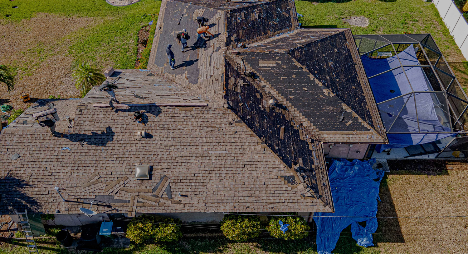 sky view photo of a roof with workers removing the shingles