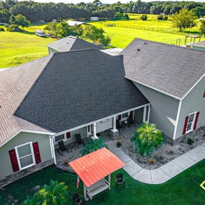 Sky view of a single family home with a gray shingle roof.
